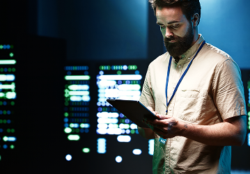 Engineer monitoring servers on a tablet in a data center